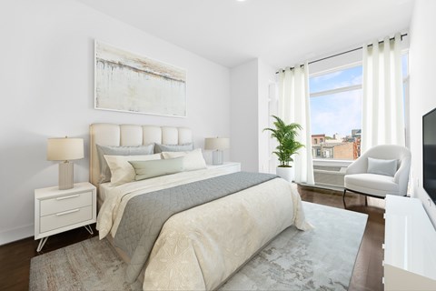 A bedroom with a large bed and a painting on the wall.